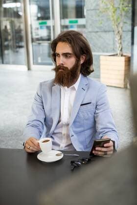Stylish businessman holding cell phone in a cafe model released Symbolfoto  MAUF000750