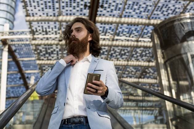 Stylish businessman using cell phone on escalator model released Symbolfoto  MAUF000767