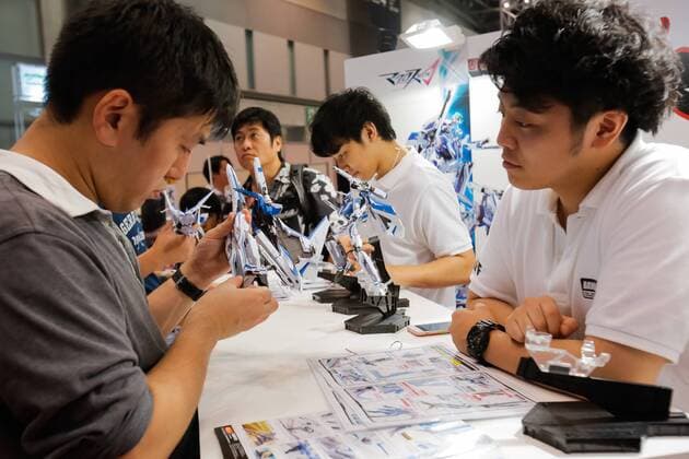 Macross fans test action figures at the 56th All Japan Model & Hobby Show in Tokyo Big Sight on September 25, 2016. The exhibition introduced hobby goods such as plastic models, action figures, drones, and airsoft guns.  (gxta_alljpnmodelhobbyshow003)
