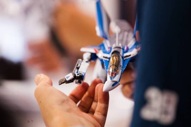 A visitor tests an action figure of the fiction mecha anime Macross at the 56th All Japan Model & Hobby Show in Tokyo Big Sight on September 25, 2016. The exhibition introduced hobby goods such as plastic models, action figures, drones, and airsoft guns.  (gxta_alljpnmodelhobbyshow026)