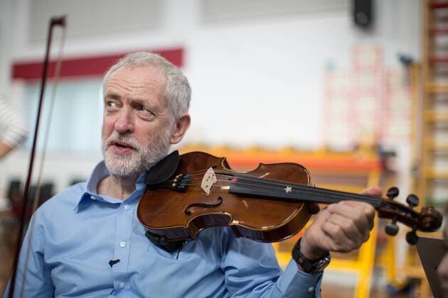 September 27, 2016 - Liverpool, Merseyside, UK - Liverpool , UK . Labour Party leader JEREMY CORBYN is shown how to play the violin by JESSICA KELLY (10) during a visit to Faith Primary School in Liverpool , where he listens to and then joins in with the school orchestra Liverpool UK  - ZUMAl94_