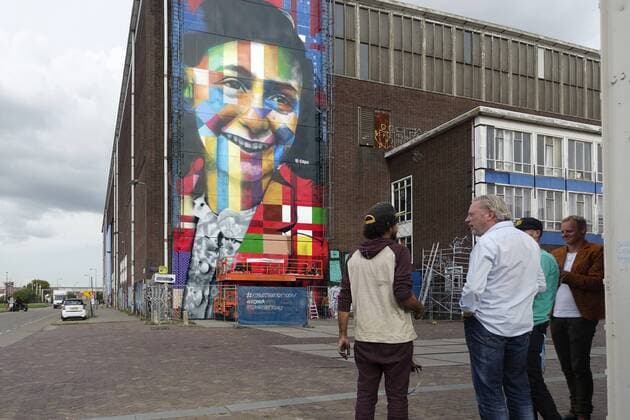 The Netherlands, Amsterdam. The famous Brazilian street artist Eduardo Kobra realizes this week a monumental portrait of Anne Frank. 26 september 2016, Photo: Katrien Mulder Hollandse Hoogte Nederland, Amsterdam, Amsterdam Noord, NDSM Terrein, wereldberoende Braziliaanse streetartist Eduardo Kobra (l) realiseert deze week een monumentaal portret van Anne Frank op de zuidelijke buitenmuur van de loods op de hoek van de MS van Riemsdijkweg, en de Tt Neveritaweg famous Brazilian street artist Eduardo Kobra (l) realizes this week a monumental portrait of Anne Frank, 26 september 2016, foto: Katrien Mulder  59396749