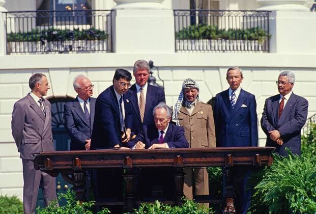 September 13, 1993 - Washington, District of Columbia, United States of America - Minister of Foreign Affairs of Israel Shimon Peres puts his signature on the agreement during the signing ceremony of the historic Israeli-PLO Agreement, known as the Oslo 1 Accord, on the South Lawn of the White House in Washington, DC on September 13, 1993. Pictured, from left to right: From left to right are: Foreign Minister Andrei Kozyrev of Russia; Prime Minister Yitzhak Rabin of Israel; unknown aide; United States President Bill Clinton; Peres; Chairman Yasser Arafat of the Palestine Liberation Organization (PLO); US Secretary of State Warren Christopher; and Arafat aide Mahmoud Abbas..Credit: CNP Washington United States of America - ZUMAs152
