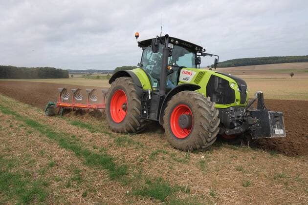 Auf einem Acker in Goslar am Harz im Ortsteil Weddingen im Bundesland Niedersachsen wird mit einem Fünf Schar Volldrehpflug mit Packomat und einem Traktor der Marke Claas Axion 830 in leichter Hanglage gepflügt. u.B.z. 5 Schar Volldrehpflug mit Packomat und Claas Axion im Einsatz auf Ackerboden. Ein Pflug ist ein landwirtschaftliches Gerät zur Lockerung und zum Wenden des Ackerbodens im Bereich des Bearbeitungshorizontes. Pflügen in Hanglage mit einem Fünf Schar Volldrehpflug mit Packomat in Goslar am Harz im Bundesland Niedersachsen.
