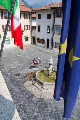 Rennradfahrer auf dem Alpe Adria-Weg auf der Piazza in Venzone, 1976 vom Erdbeben zerstört und wieder aufgebaut Venzone Nord-Italien Italien Alpe-Adria-Weg