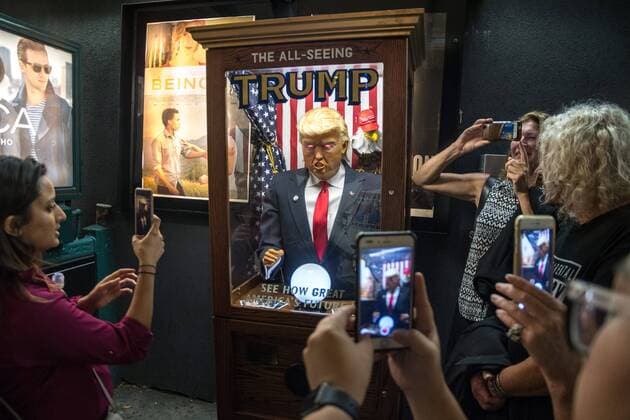 People surround and photograph a fortune-telling fairground attraction representing Republican presidential candidate Donald Trump outside a New York theater screening the premiere of the documentary Michael Moore In TrumpLand on October 18, 2016. Filmmaker Michael Moore had finished editing the film the previous day and made a surprise last-minute announcement on Twitter that he would show it for free today. The film will play for a week in Los Angeles and New York starting tomorrow. Photo by Enrique Shore Cordon Press  ENRIQUExSHORE People surround robot of Trump before premiere of the documentar