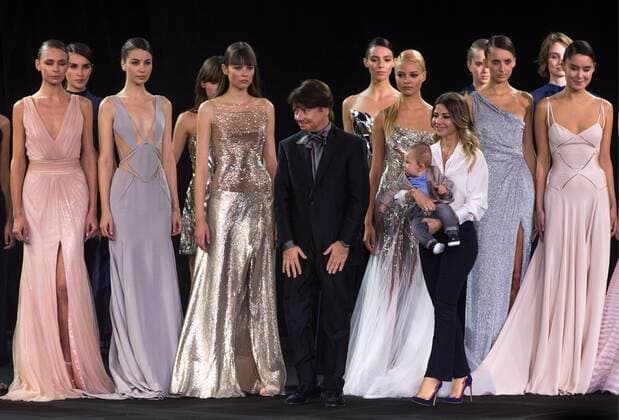 MOSCOW, RUSSIA - OCTOBER 18, 2016: Designer Valentin Yudashkin with daughter Galina and grandson Anatoly (L-R front) acknowledges the audience after a runway show for his Spring Summer 2017 collection at the 2016 Moscow Fashion Week, in Moscow s Gostiny Dvor Shopping and Exhibition Centre. Dmitry Serebryakov TASS  TS034D9F