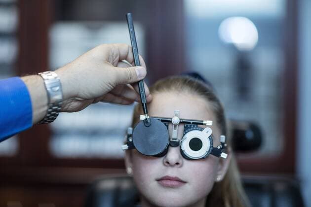 Girl doing eye test at optometrist model released Symbolfoto property released  ZEF10589