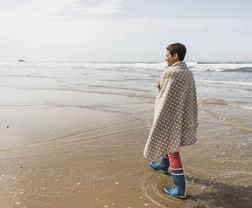 IMAGO Creative: Internationaler Frauenmonat, Gesundheit, Frauen in der Menopause Mature woman walking on the beach model released Symbolfoto  UUF08567