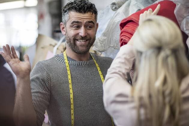 Smiling tailor looking at fashion designer in workshop model released Symbolfoto property released  ZEF10674