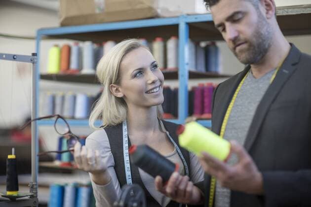 Fashion designer and seamstress examining cotton reels model released Symbolfoto property released  ZEF10677