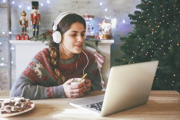 IMAGO Creative, Weihnachten, Tradition: Weihnachtsfilme sehen Woman with cup of coffee using laptop and headphones at Christmas time model released Symbolfoto property released  RTBF00430