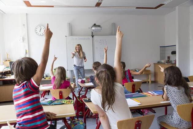 Active pupils raising their hands in class model released Symbolfoto property released  SARF02896