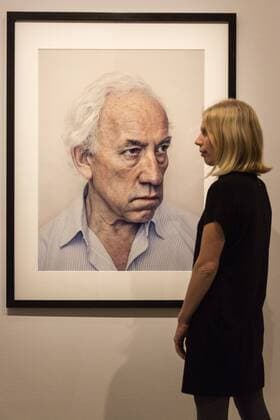 Taylor Wessing Photographic Portrait Prize 2016, National Portrait Gallery, London, UK London, UK. 16 November 2016. An NPG employee poses with a portrait of actor Simon Callow by Andy Lo Po. Press preview of the Taylor Wessing Photographic Portrait Prize 2016 at the National Portrait Gallery. The exhibition of the winning entries and shortlisted portraits runs from 17 November 2016 to 26 February 2017.