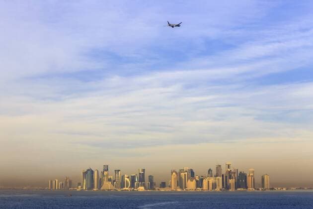 Jet airplane after take off from Hamad International Airport, seen above Doha city skyline from the sea, Qatar, Middle East Copyright: EleanorxScriven 1167-1016
