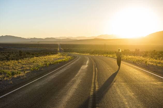 Woman walking down a long winding road at sunset in eastern Nevada, United States of America, North America Copyright: MichaelxRunkel 816-7692