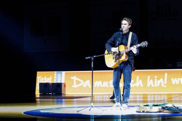 Erfurt, 221116 , Oettinger Rockets gegen NÜR Nürnberg Falcons BC im Bild: Clueso singt mit Gitarre auf dem Spielfeld , Thomas Hübner