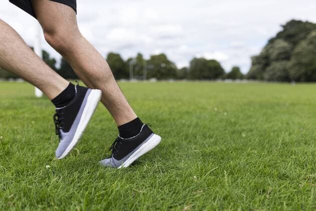 Legs of athlete running on grass model released Symbolfoto  BOYF00660