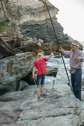 Happy boy holding fish on fishing line caught by his grandfather model released Symbolfoto  DAPF00437