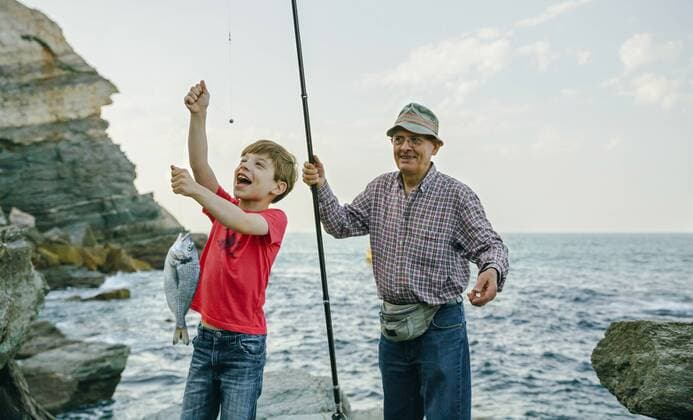 Happy boy holding fish on fishing line caught by his grandfather model released Symbolfoto  DAPF00438