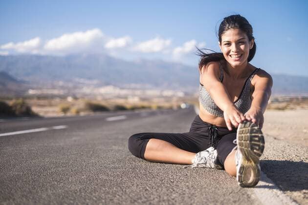 Young woman doing stretching exercises on an empty road model released Symbolfoto  SIPF01030