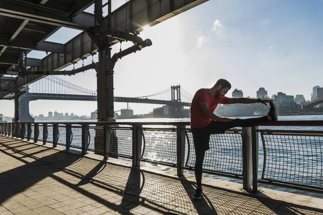 USA, New York City, sportive man stretching at East River model released Symbolfoto  UUF08829