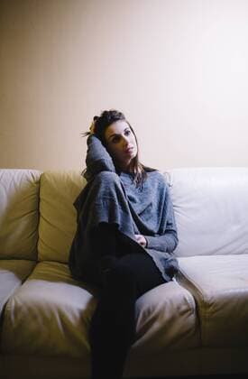 IMAGO Creative: Gesundheit, Burnout Portrait of lonely woman sitting on the couch at night model released Symbolfoto property released  JRFF00989