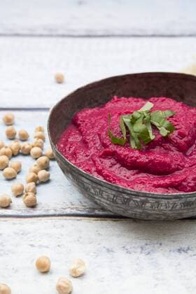 IMAGO Nature: Unsere Erde, Klimawandel, Ernährung, Pflanzen der Zukunft, Kichererbse Bowl of beetroot hummus an chick-peas on wood  LVF05586
