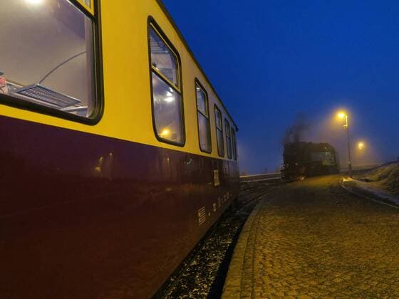 Fahrt mit der Dampflokomotive der Harzer Schmalspurbahnen bei Nacht zum Brocken. u.B.z. Bahnhof Brocken im Neonlicht mit bereitstehender Lokomotive und Lokomotivführer. Die Harzer Schmalspurbahnen GmbH (HSB) mit Sitz in Wernigerode ist eine Eisenbahngesellschaft die ein zirka 140 km langes Netz von zumeist dampfbetriebene Schmalspurstrecke im Harz betreibt. Es handelt sich heute um das längste zusammenhängende dampfbetriebene Streckennetz in Europa. Dieses Netz mit der Spurweite von 1000 mm (Meterspur) besteht aus den Strecken Harzquerbahn, Selketalbahn und Brockenbahn. Auch die Anfangsbuchstaben der Strecken ergeben das Kürzel der Bahngesellschaft. Die Strecken sind ganzjährig in Betrieb. Fahrt mit der Dampflokomotive der Harzer Schmalspurbahnen von Wernigerode bei Nacht zum Brocken im Bundesland Sachsen Anhalt.