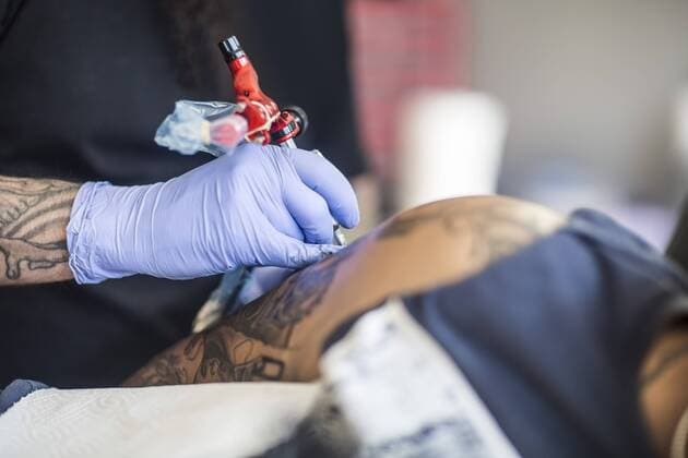 Tattoo artist tattooing an arm model released Symbolfoto property released  ZEF11585
