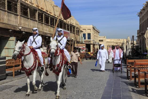 Busy street scene with traditionally dressed mounted policemen and shoppers, Souq Waqif, Doha, Qatar, Middle East Copyright: EleanorxScriven Editorial Use Only 1167-1018