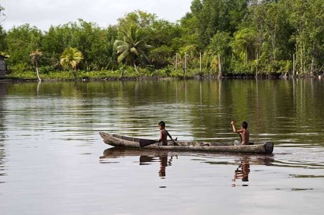 Amerindian boys paddling dugout canoe, Maharuma, Guyana, South America Copyright: MickxBainesx&xMarenxReichelt 971-34