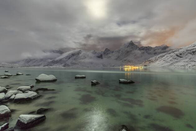Full moon lights up the snow capped peaks reflected in the cold sea, Vareid, Flakstad, Nordland, Lofoten Islands, Northern Norway, Scandinavia, Europe Copyright: RobertoxMoiola 1179-1351