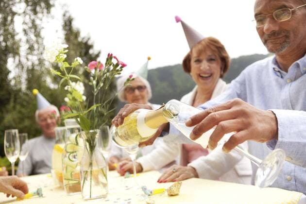Geburtstag - Symbolbilder Senior people celebrating, man pouring champagne into glass model released Symbolfoto property released  MFRF00779