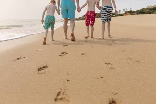Father and sons walking on the beach model released Symbolfoto  NMSF00002