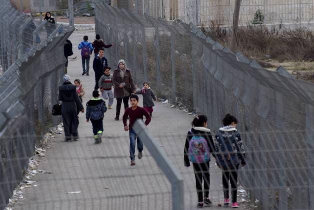 Palestinians walk through wire fences on a path that leads to a checkpoint in the Israeli separation wall that surrounds the Shurafat Refugee Camp northeast of Jerusalem, January 15, 2017. Representatives of 72 countries are meeting today in Paris for a one day Peace Summit in the latest bid to restart peace talks between Israel and the Palestinians. Israeli Prime Minister Benjamin Netanyahu says the Paris peace talks are useless while the Palestinians welcome the multinational approach to brings the two sides to the negotiating table.  JER2017011518 DEBBIExHILL