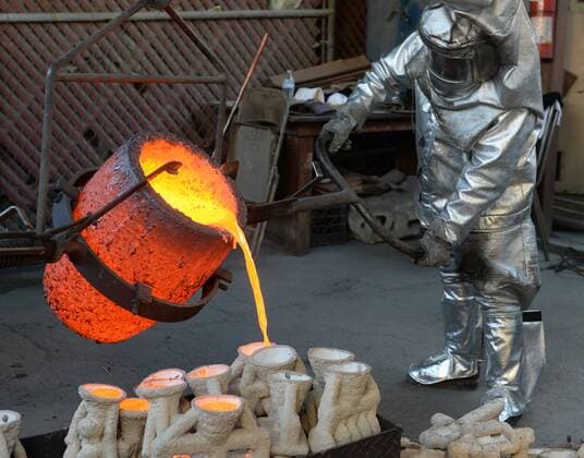 Workers in fire suits pour molten bronze metal into molds during the casting of the Screen Actors Guild Award statuettes at the American Fine Arts Foundry in Burbank, California on January 17, 2017. Winners are to be announced during a live simulcast on TNT and TBS in Los Angeles on January 29, 2017.  LAP2017011705 JIMxRUYMEN