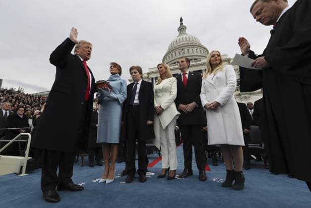U.S. President Donald Trump takes the oath of office as his wife Melania holds the bible and his children Barron, Ivanka, Eric and Tiffany watch as U.S. Supreme Court Chief Justice John Roberts (R) administers the oath in Washington, DC on January 20, 2017. Pool photo by Jim Bourg  WAX20170120612 JIMxBOURG