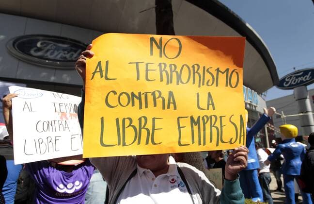 A protestor holds a banner that reads No to terrorism against free market during a demonstration against Donald J.Trump s inauguration as 45th President of the United States, in front of a Ford authorised dealer, in Mexico City, Mexico, 20 January 2017. Ford cancelled a 1,600 million dollars invesrment in the country after Trump threatened the company to charge them a 35 per cent duty and General Motors decided to move part of its production to the US. EFE Mario Guzman PROTEST AGIANST DONALD TRUMP S INAUGURATION IN MEXICO !ACHTUNG: NUR REDAKTIONELLE NUTZUNG!  MEX001 20170120-636205495258225717