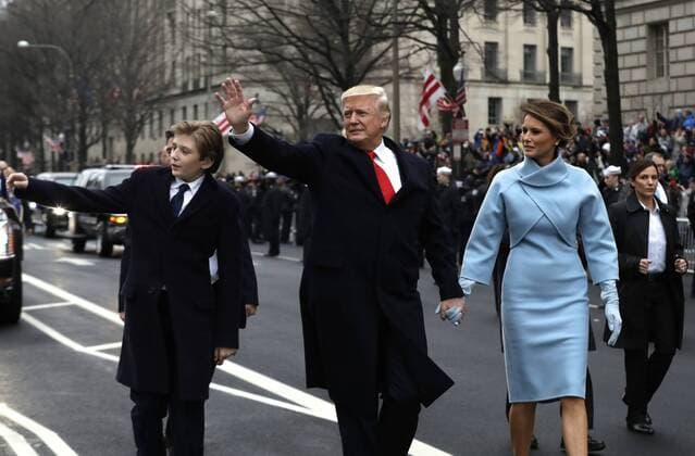 President Donald Trump waves as he walks with first lady Melania Trump and their son Barron, left, during the inauguration parade on Pennsylvania Avenue in Washington, DC on January 20, 2017. Trump became the 45th President of the United States. Pool photo by Evan Vucci  WAX201701202116 EVANxVUCCI