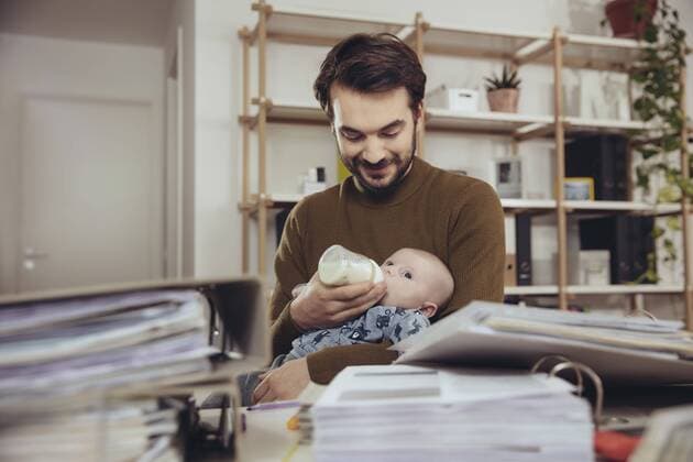 Father feeding his baby in home office model released Symbolfoto property released  MFF03429