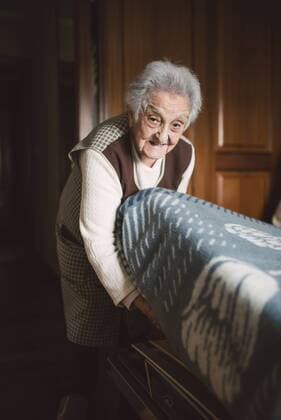 IMAGO Creative: Frühjahrsputz Senior woman putting fresh sheets on a bed model released Symbolfoto property released  RAEF01642