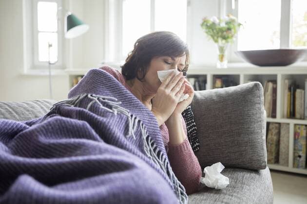 Woman having a cold lying on the sofa model released Symbolfoto property released  RBF05399