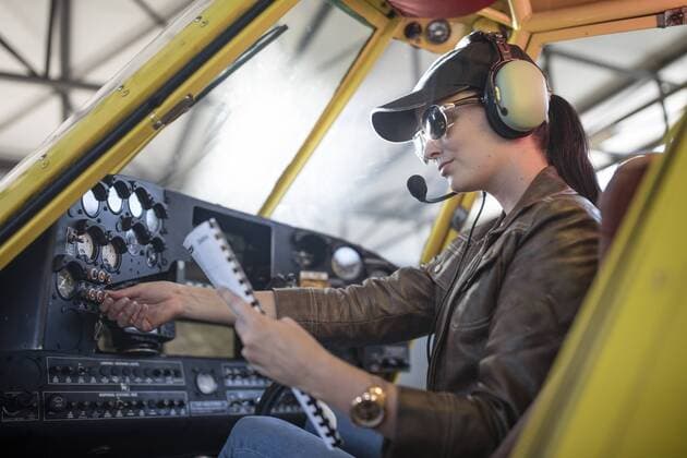 Female pilot inspecting light aircraft cockpit model released Symbolfoto property released  ZEF12242