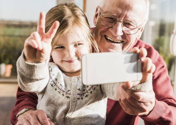 Grandfather and granddaughter taking selfies with a smart phone model released Symbolfoto property released  UUF09547