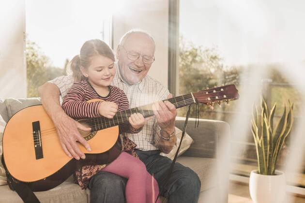 Tag der Musik am 21. Juni Grandfather and granddaughter playing together guitar model released Symbolfoto property released  UUF09555