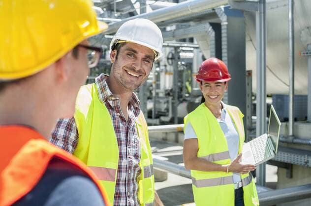 IMAGO Creative: Gesellschaft, Integration Happy engineer with his colleagues in meeting with laptop at geothermal power station, Bavaria, Germany mit_2003_10286