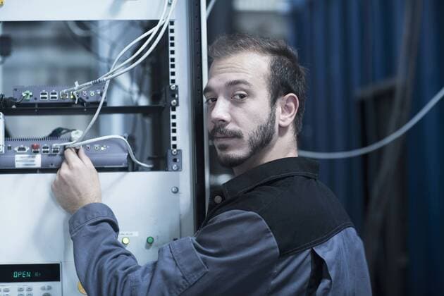 Young male engineer connecting plug in router in technology space, Freiburg Im Breisgau, Baden-Wuerttemberg, Germany mit_2024_10204
