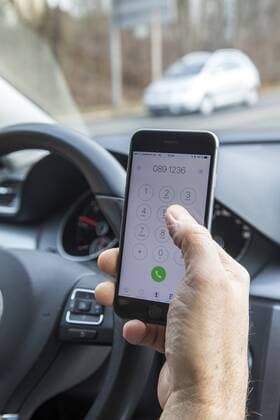 Mann, Autofahrer, benutzt ein Handy, während der Fahrt, wählt Telefonnummer, ohne Freisprecheinrichtung,