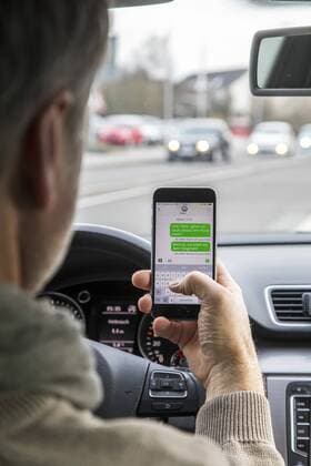Mann, Autofahrer, benutzt ein Handy, während der Fahrt, SMS schreiben,
